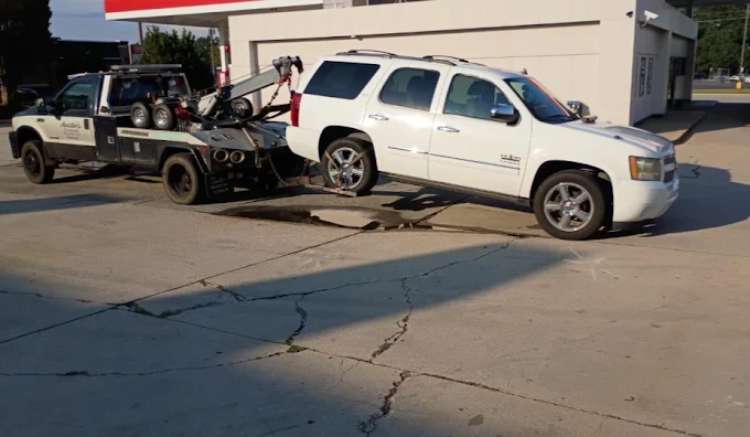 Austin's tow truck transporting a white SUV